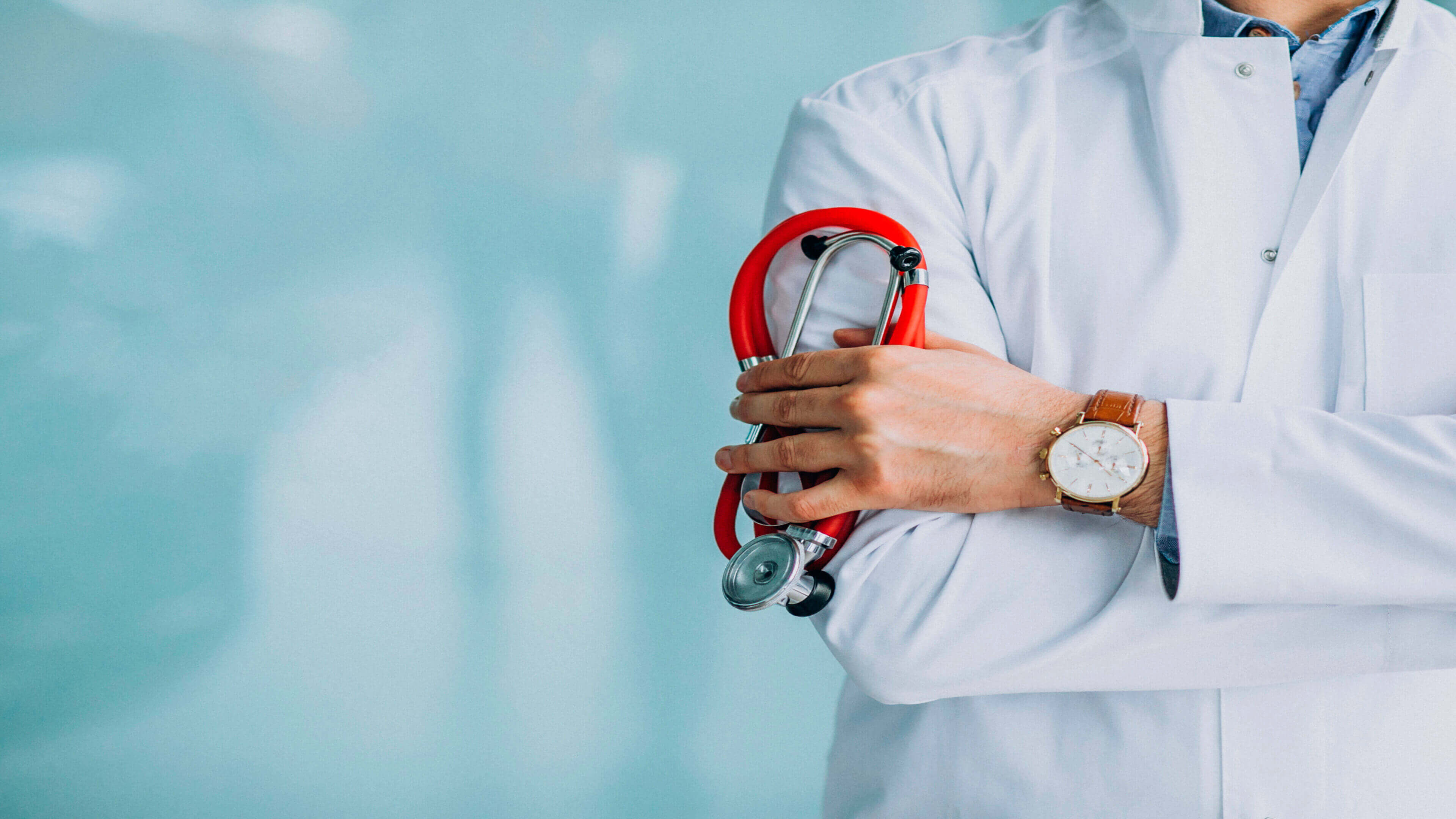 A healthcare professional holding a stethoscope with crossed arms.