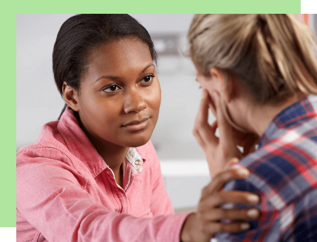 A woman attentively listens and comforts another person.