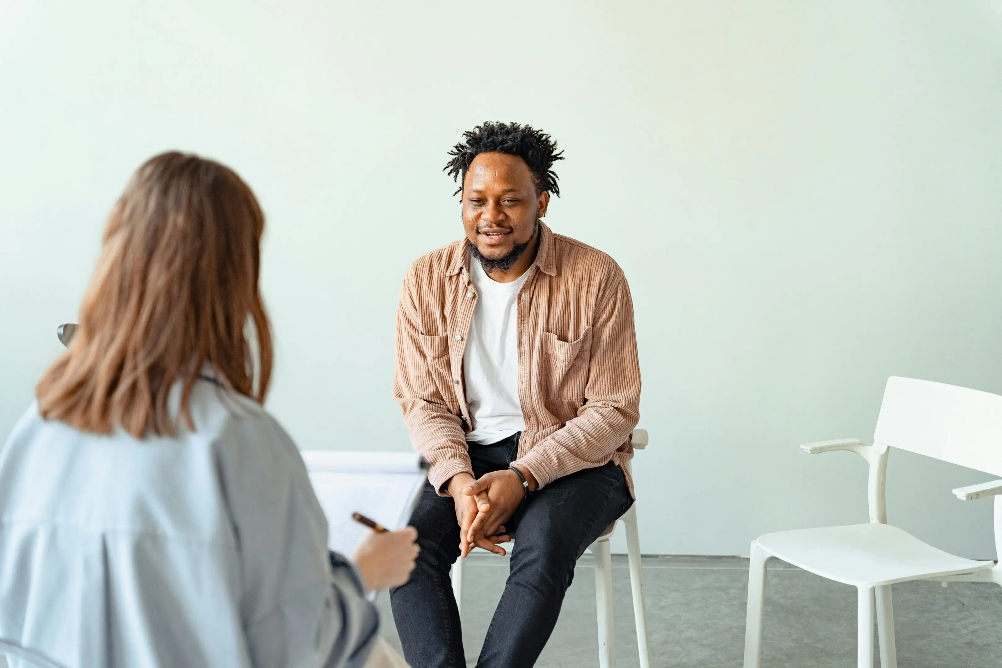 A man and woman engaged in a conversation in a casual setting.